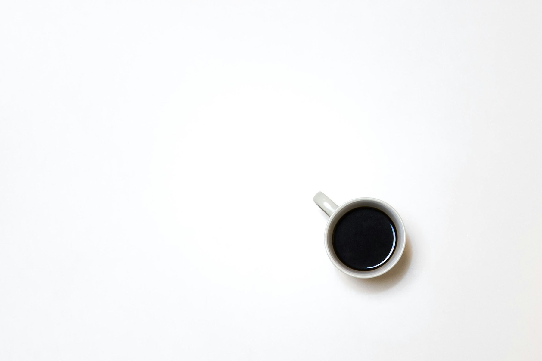 A white mug of black coffee seen from above